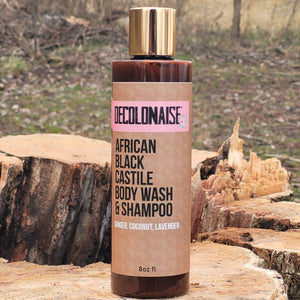 African Black Castile Body Wash and Shampoo 8 oz bottle with gold cap placed on tree stump