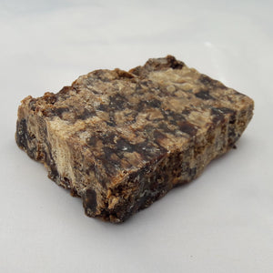 Authentic African black soap bar centered on a white background